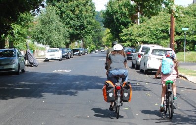 Mother and daughter bike side by side on a bike boulevard.